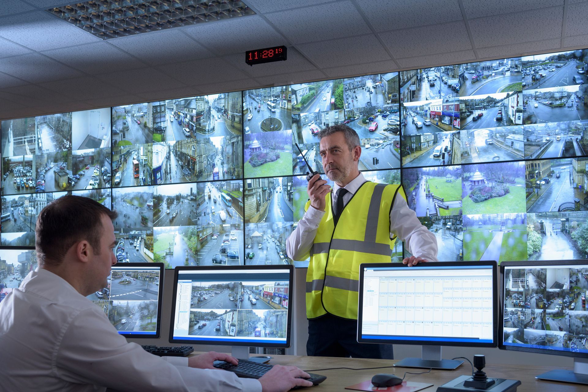 Security guards in security control room with video wall. Security guards in security control room with video wall.