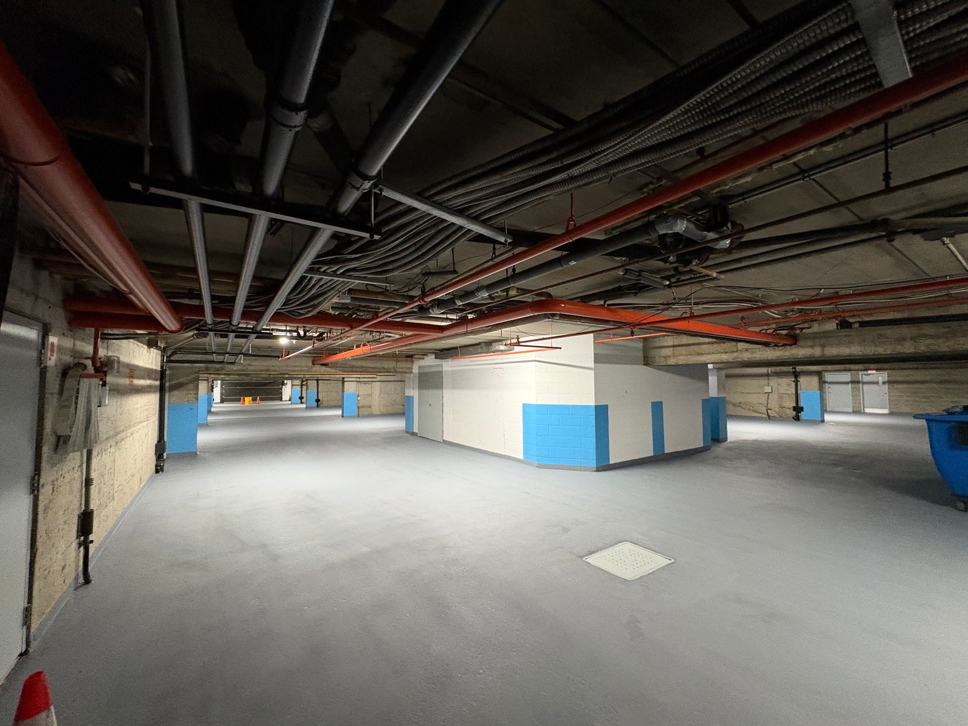 Un grand entrepôt vide avec beaucoup de tuyaux suspendus au plafond