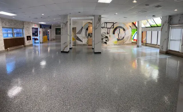 A large empty hallway with a painting on the wall.