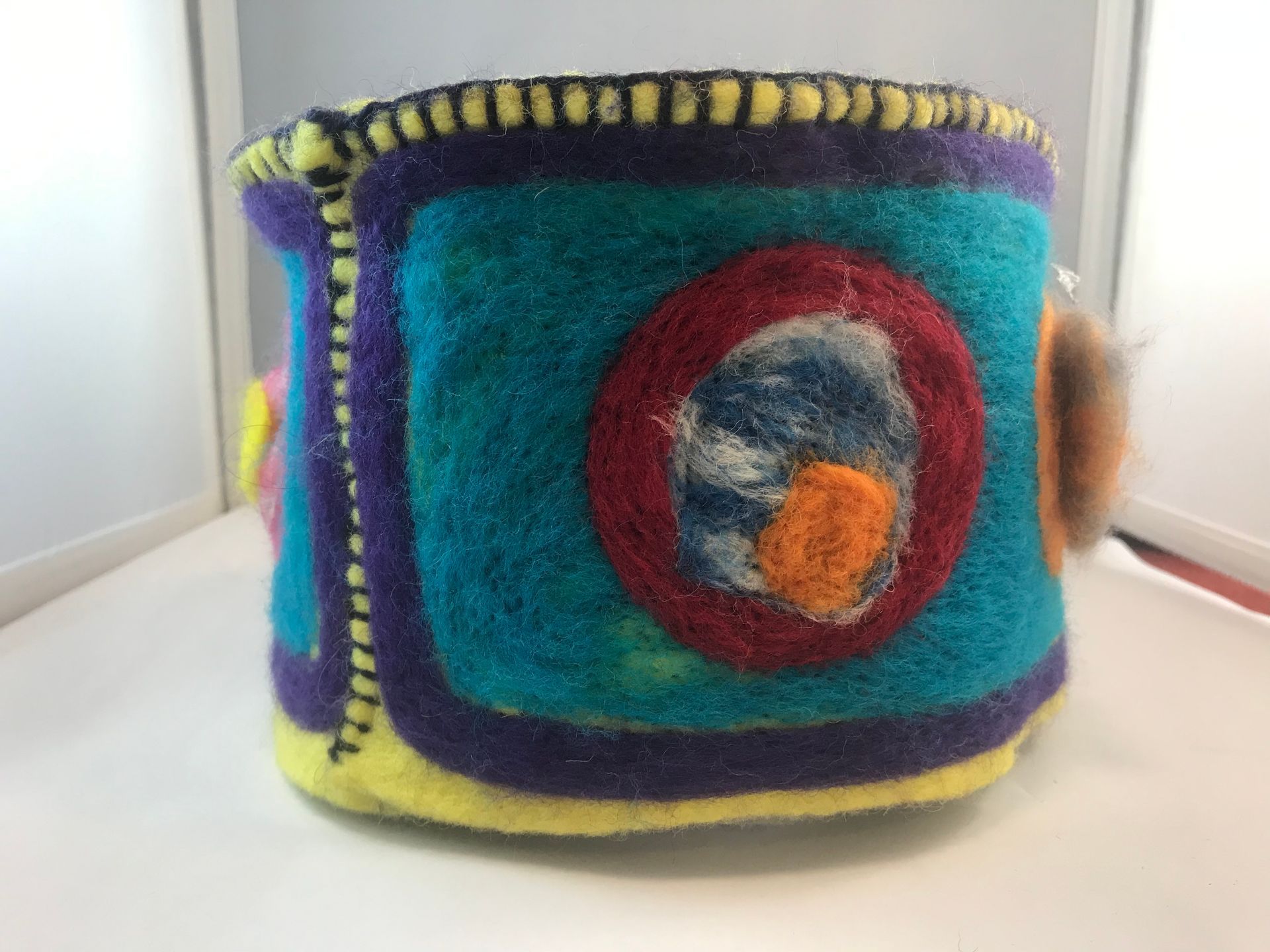 A colorful bracelet is sitting on a white table.