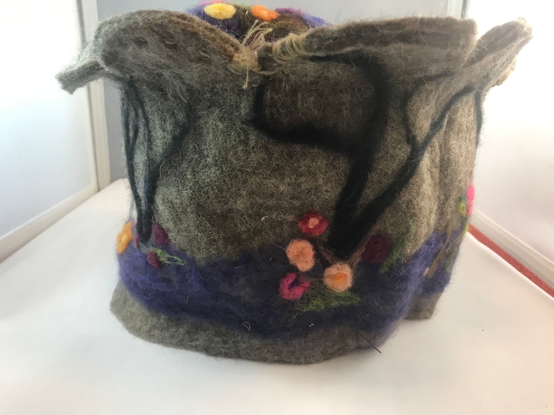A gray and purple bag with flowers on it