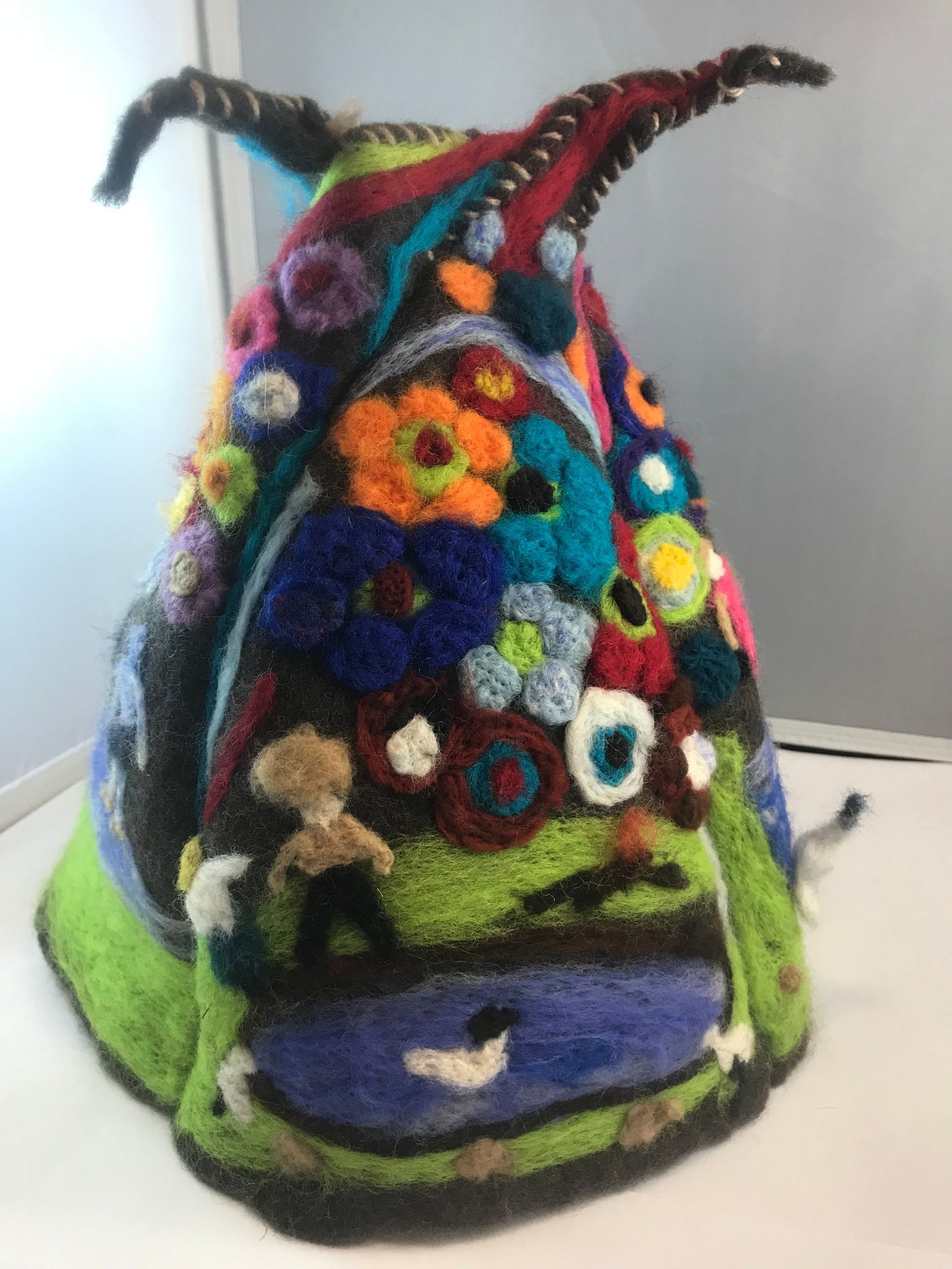 A colorful knitted hat with flowers on it