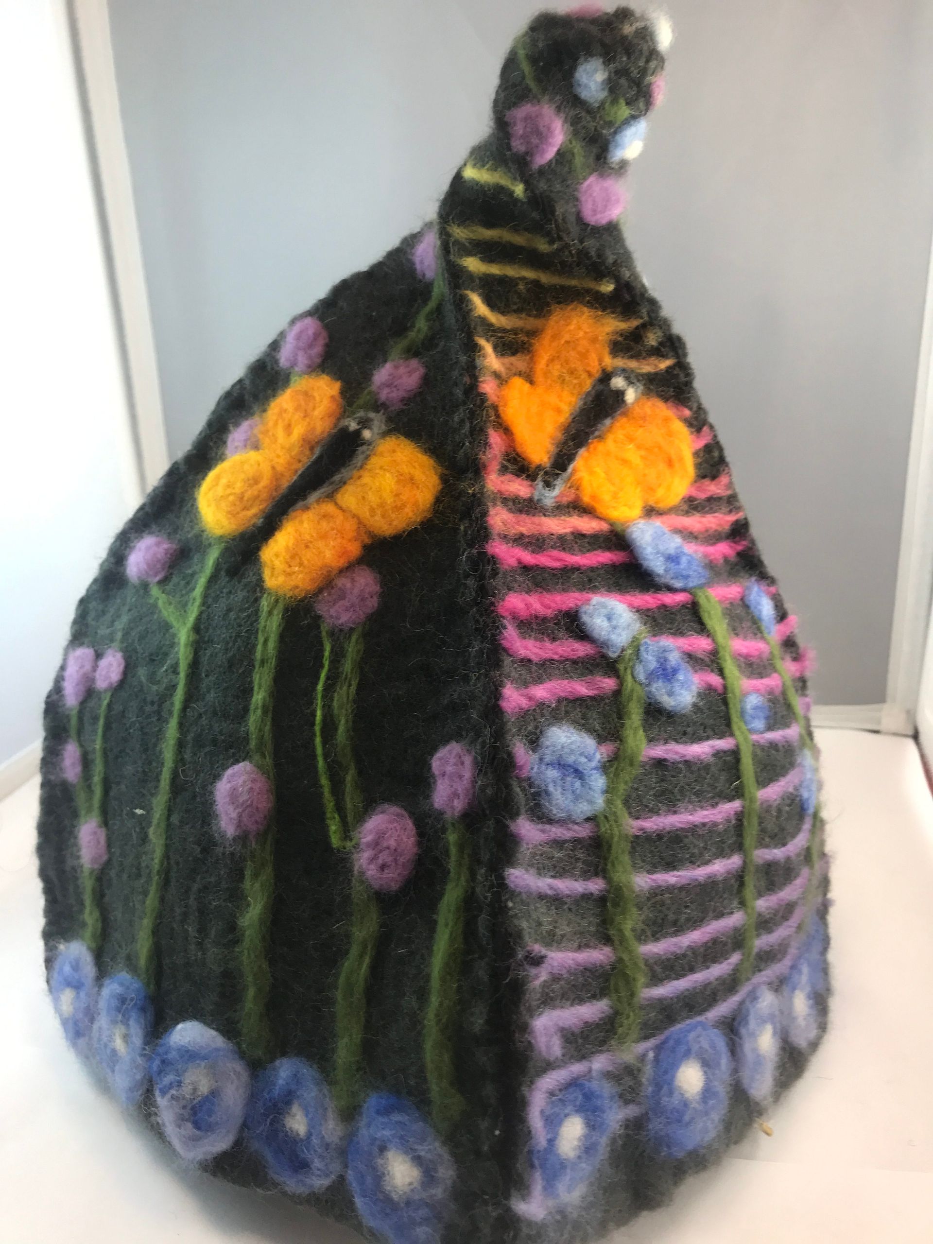 A black hat with flowers on it is sitting on a table.