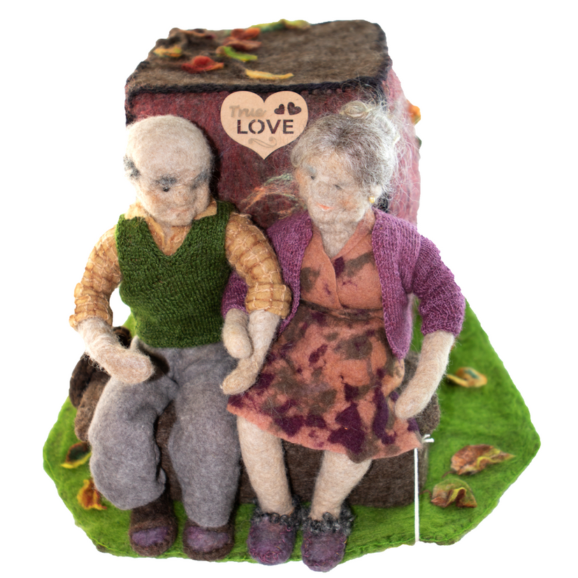 A figurine of an elderly couple with a heart that says love