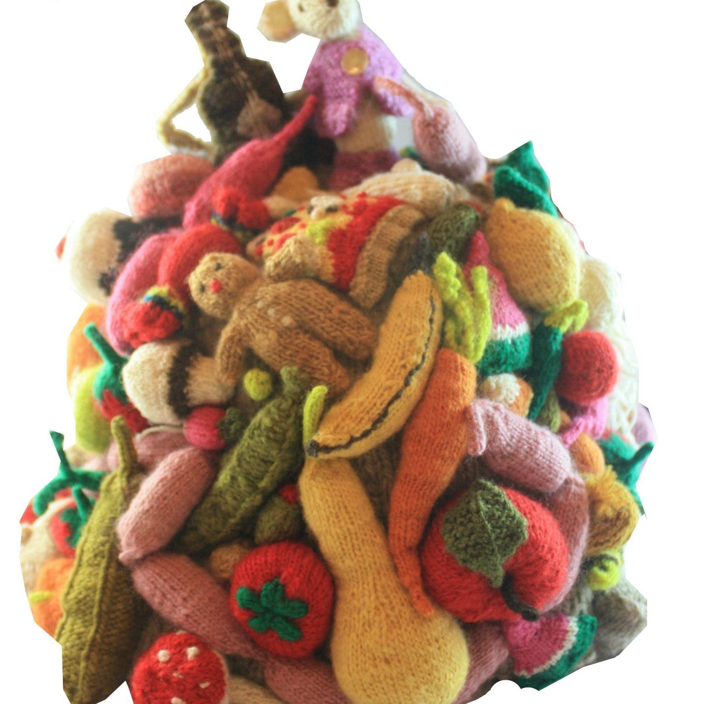 A pile of stuffed fruits and vegetables with a monkey on top