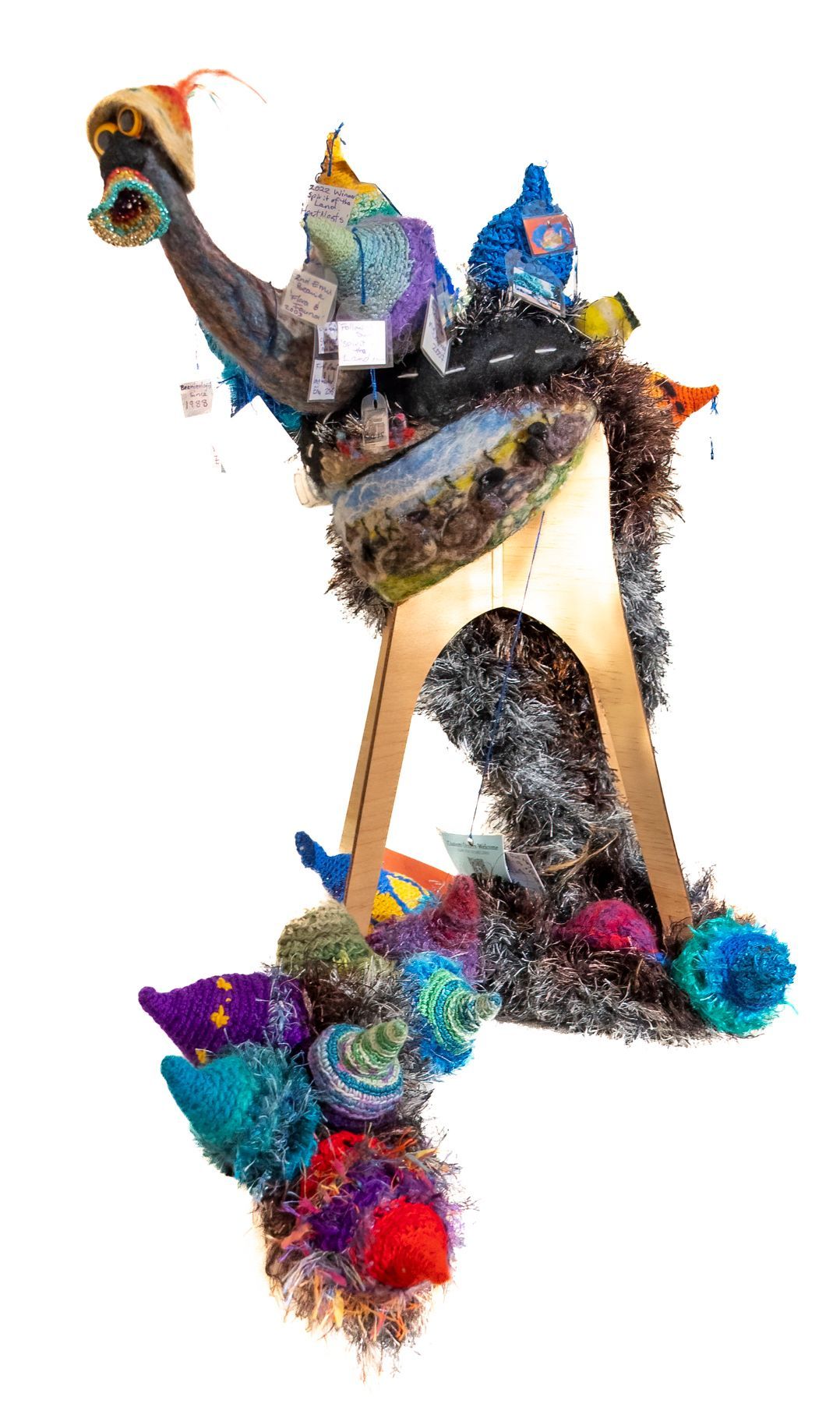 A sculpture made of yarn and tinsel on a white background.