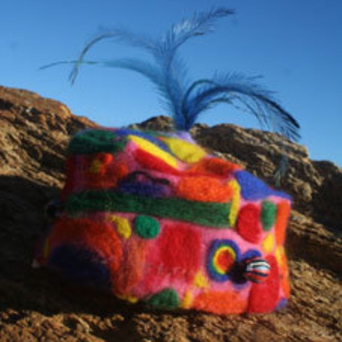 A colorful object with a blue feather on top of it