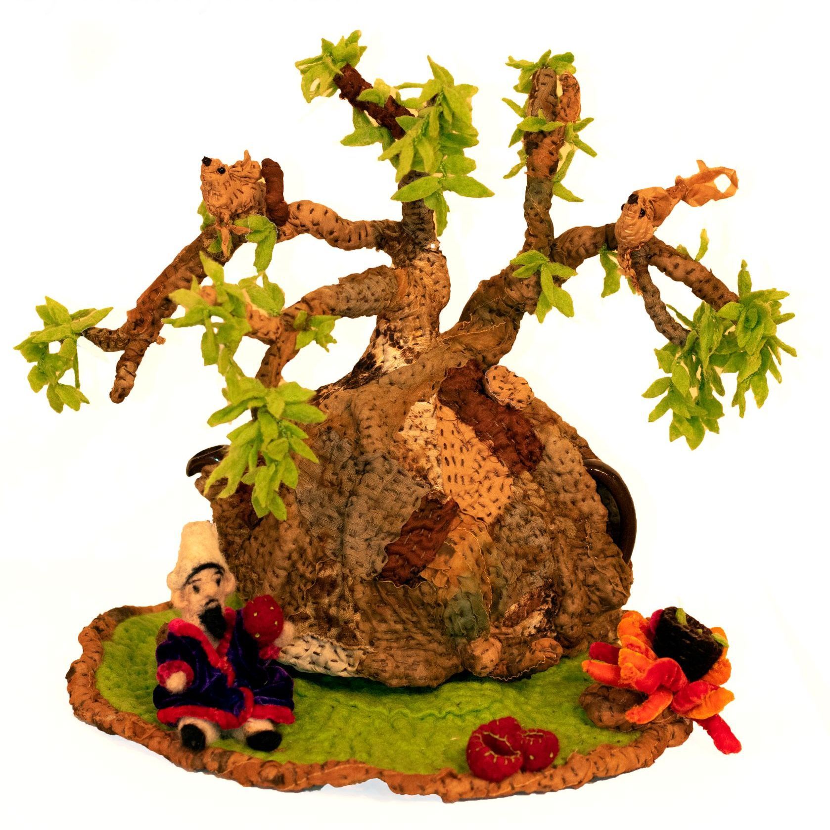 A sculpture of a tree with a gnome sitting underneath it