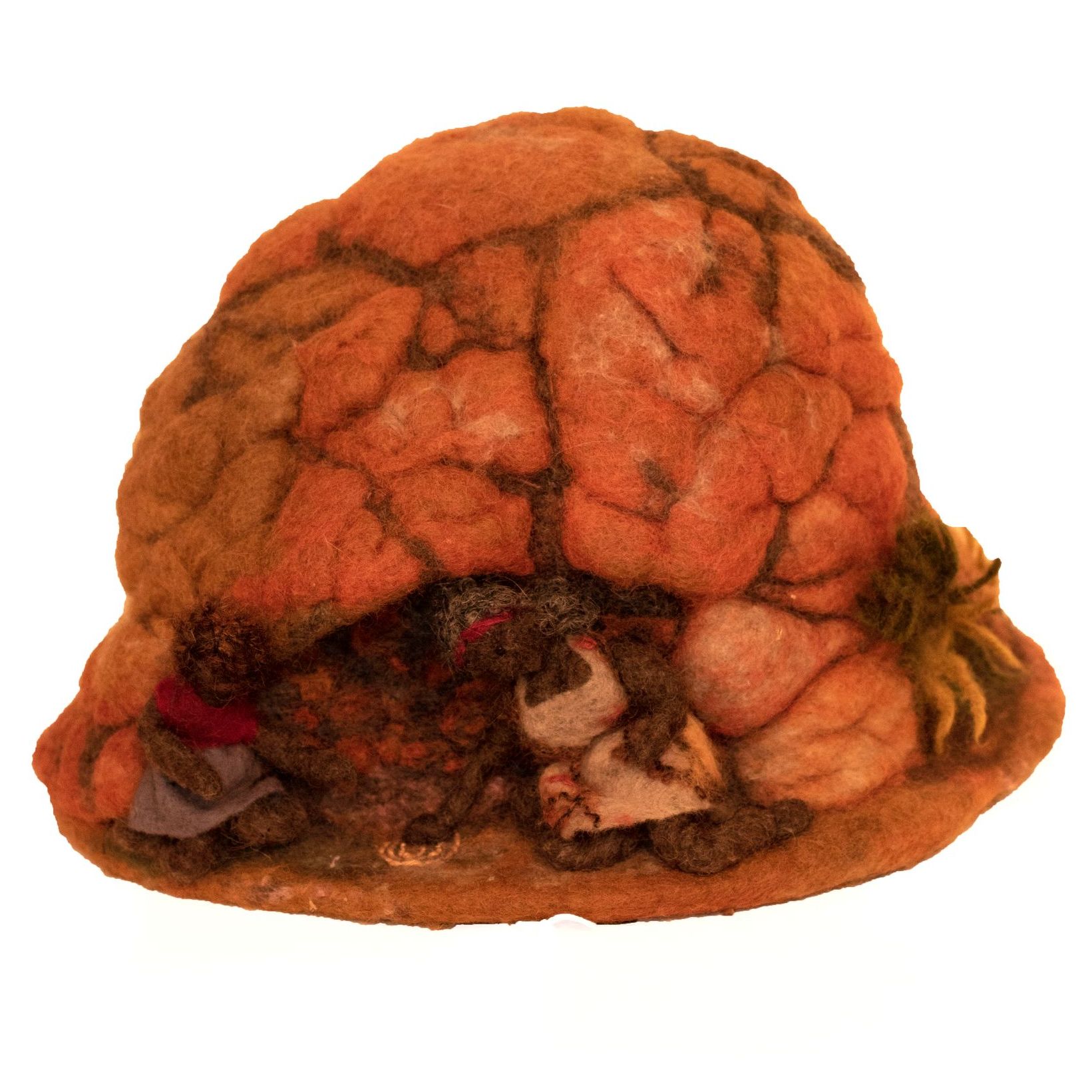 A stuffed animal is sitting in a hole in a hat