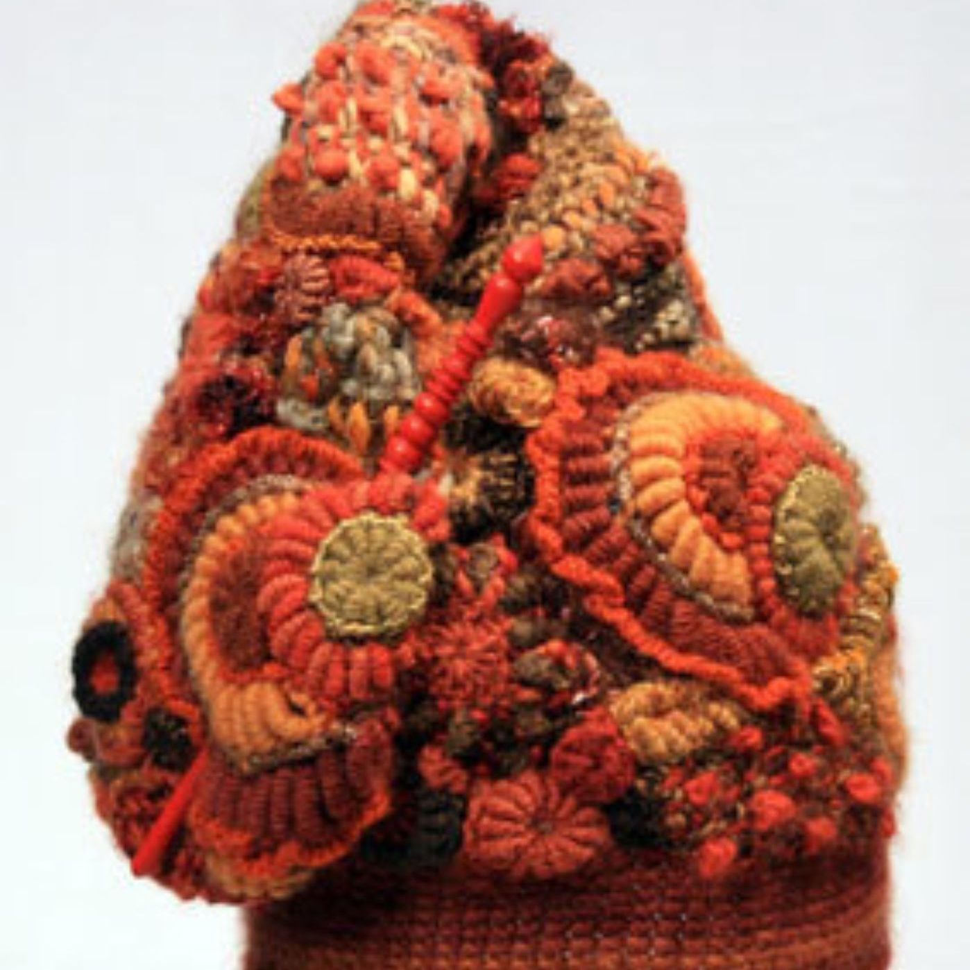 A close up of a knitted hat with flowers on it
