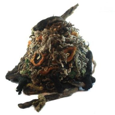 A stuffed animal that looks like an owl is sitting on a white surface