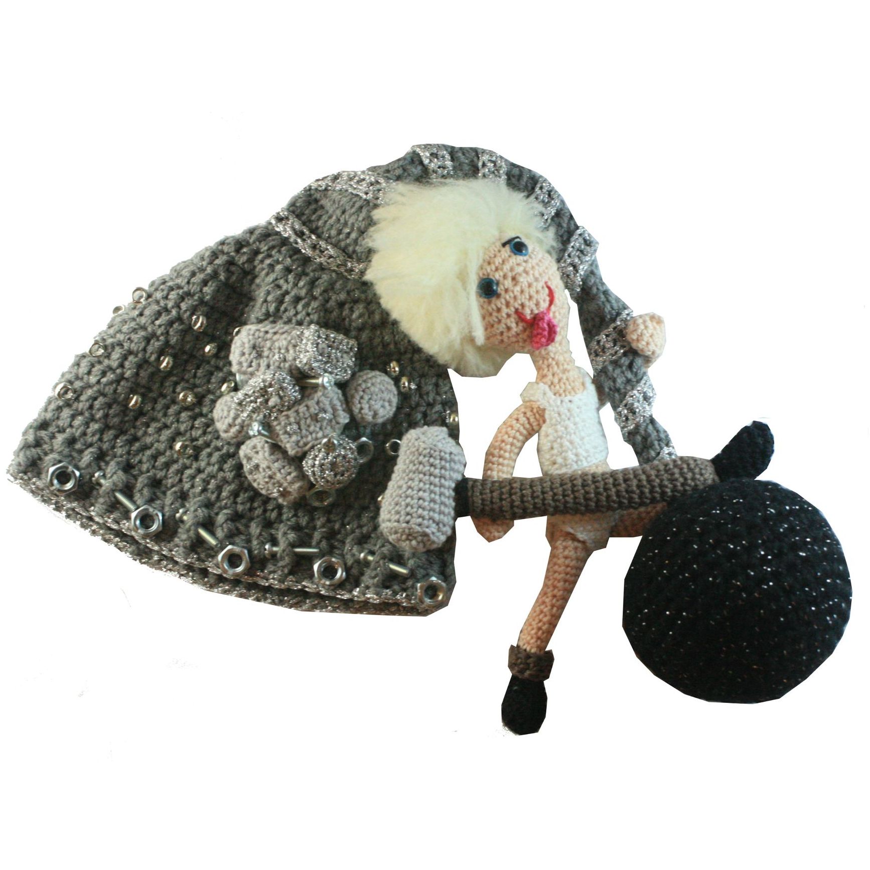 A crocheted doll is holding a black ball