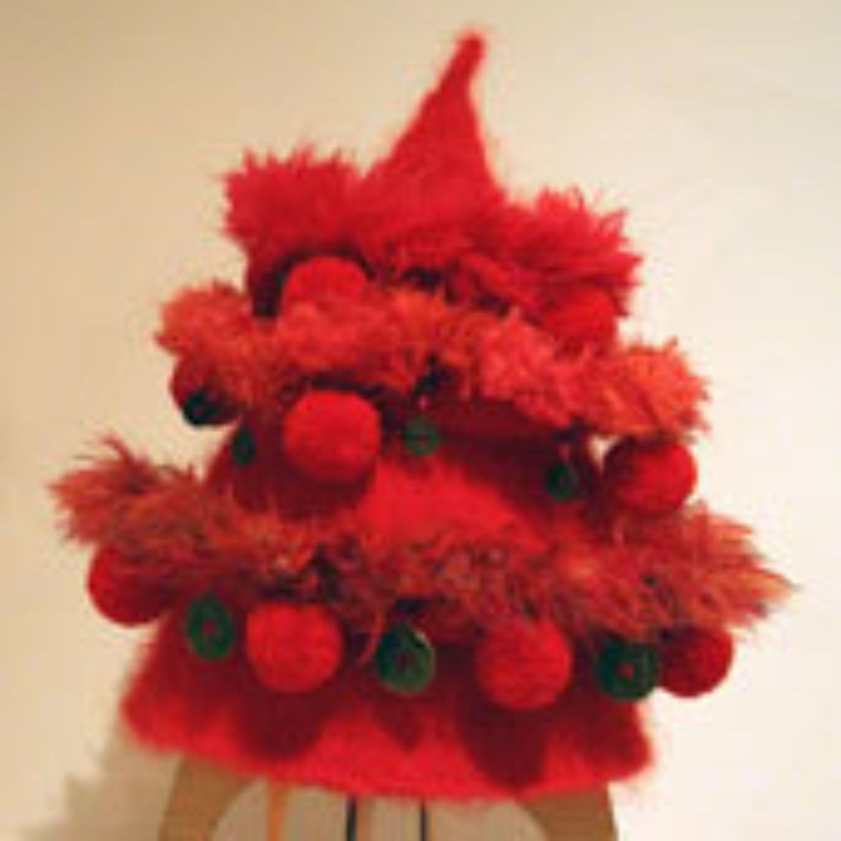 A red hat with pom poms and buttons on it