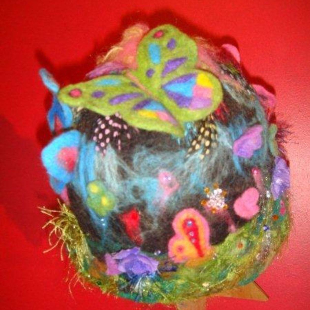 A butterfly is sitting on top of a colorful ball