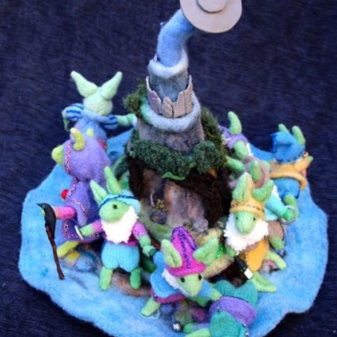A group of stuffed animals are sitting around a tower