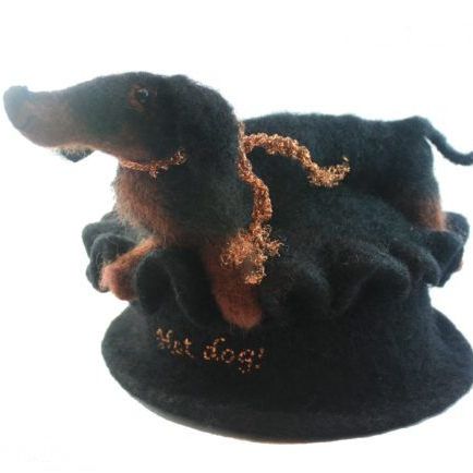 A stuffed dachshund wearing a black hat that says hot dog