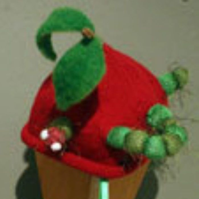 A red cupcake with a green leaf on top