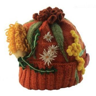 A knitted hat with flowers and leaves on it