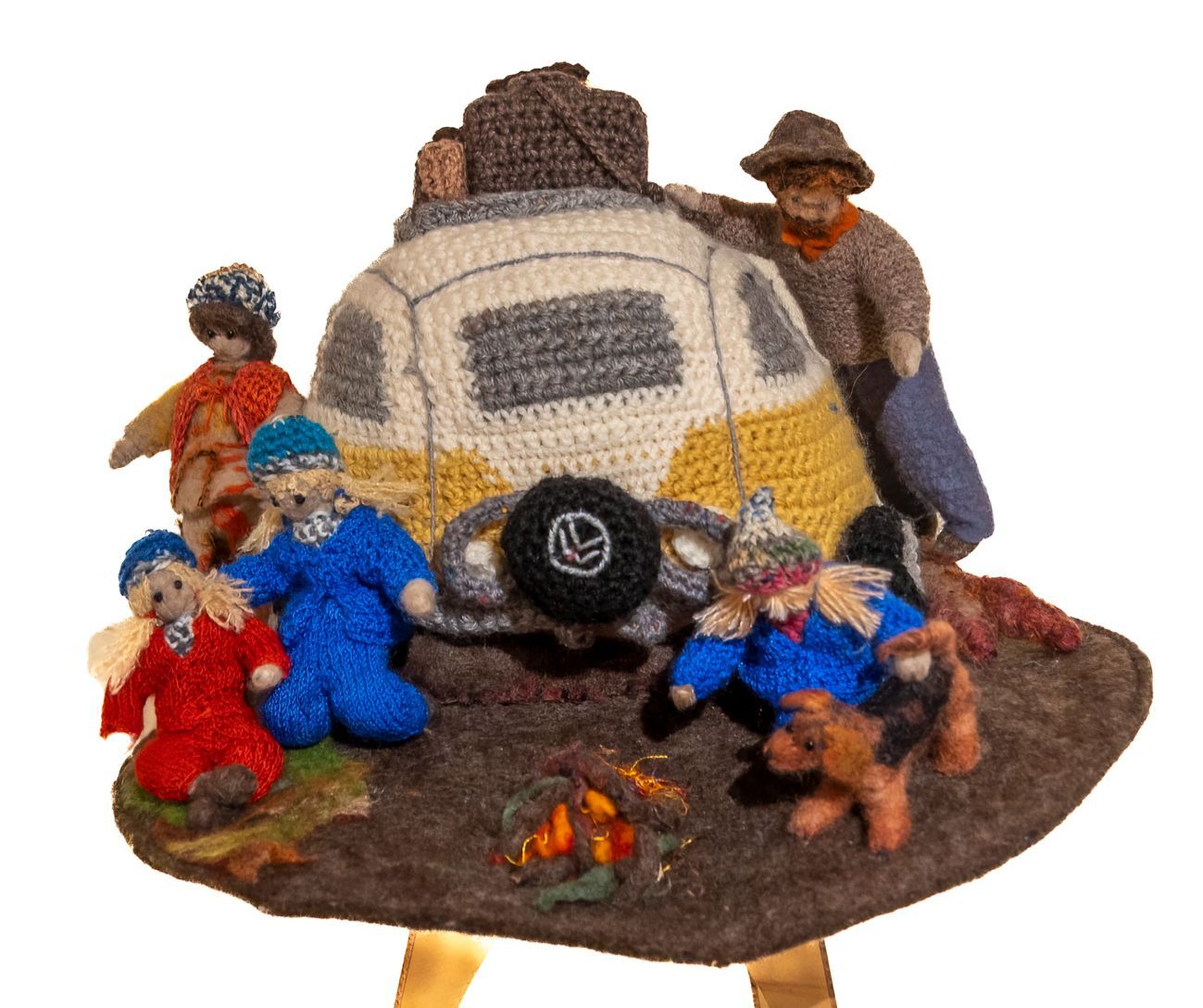 A crocheted hat with a camper and people on it