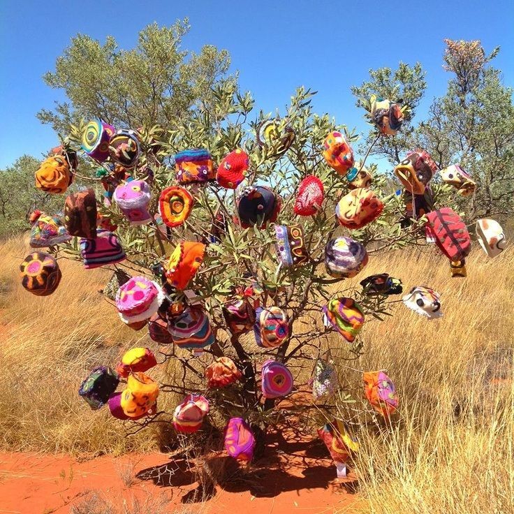 A tree with lots of balloons hanging from it