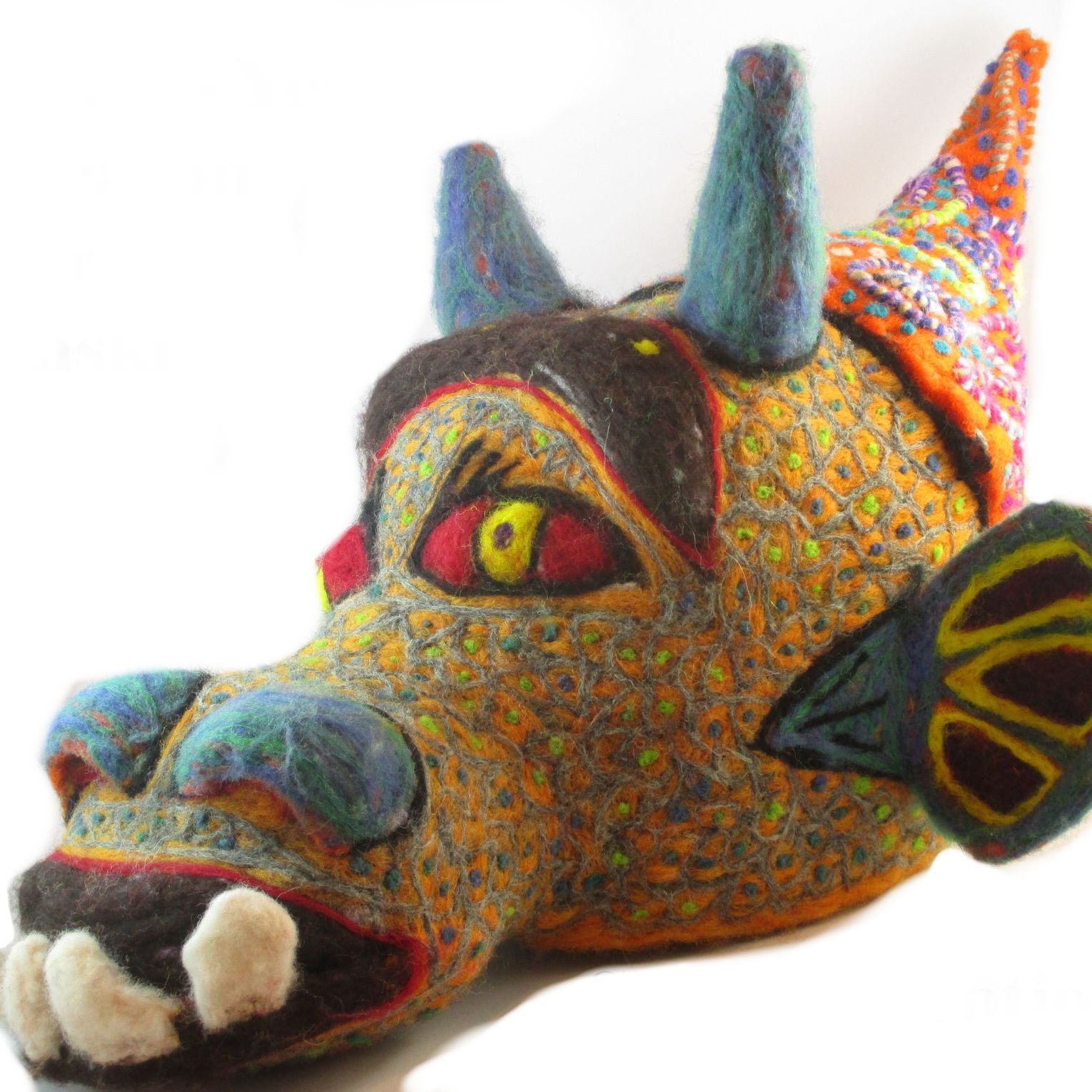 A stuffed animal with horns and wings has a yellow eye