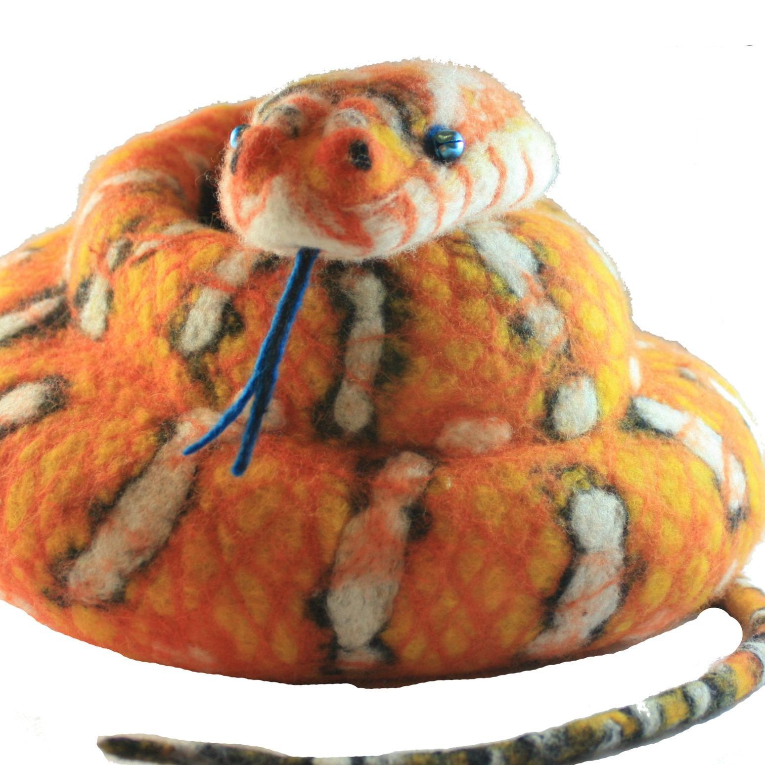 A stuffed snake with a blue tongue sticking out of its mouth