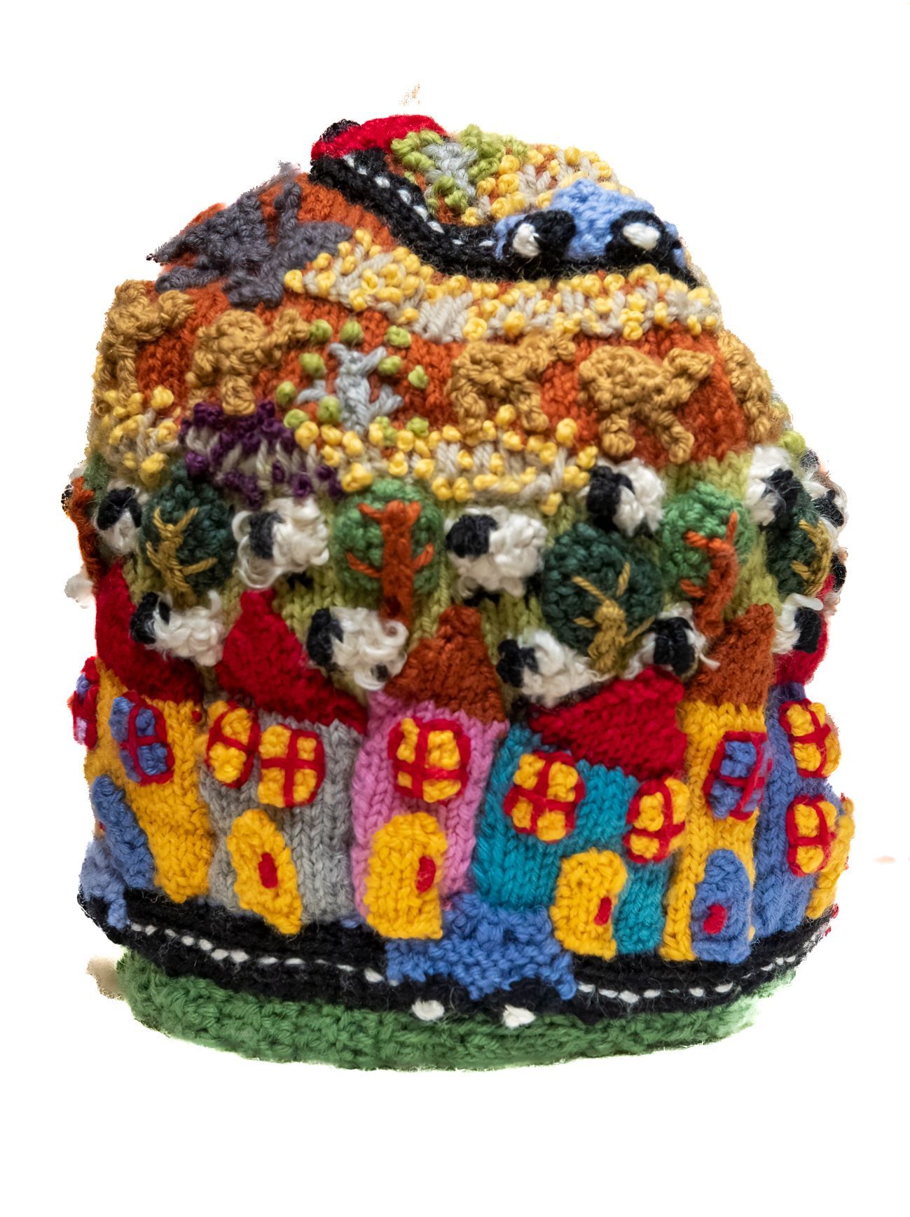 A crocheted hat with houses and a road on it