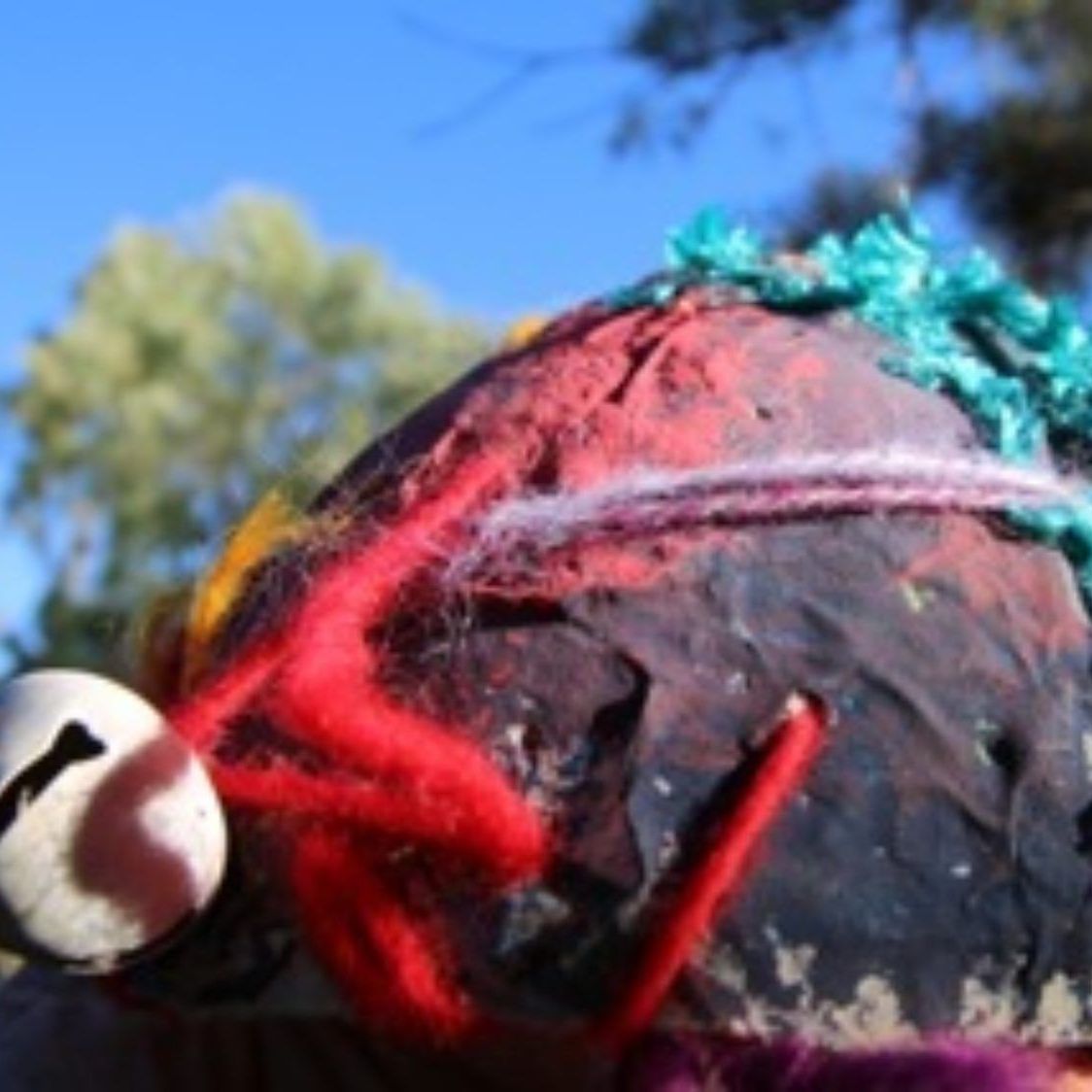 A close up of a colorful object with a bell on it