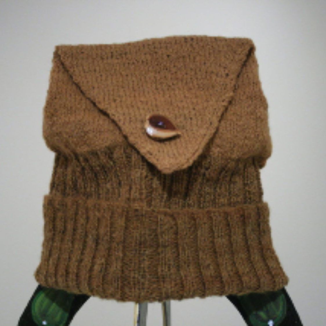 A brown sweater with a button on the front