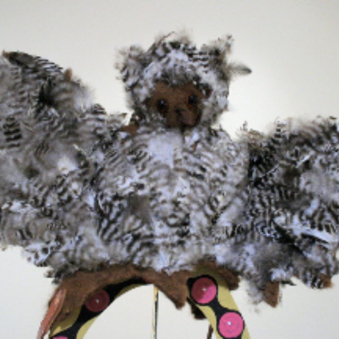 A stuffed animal that looks like an owl with wings
