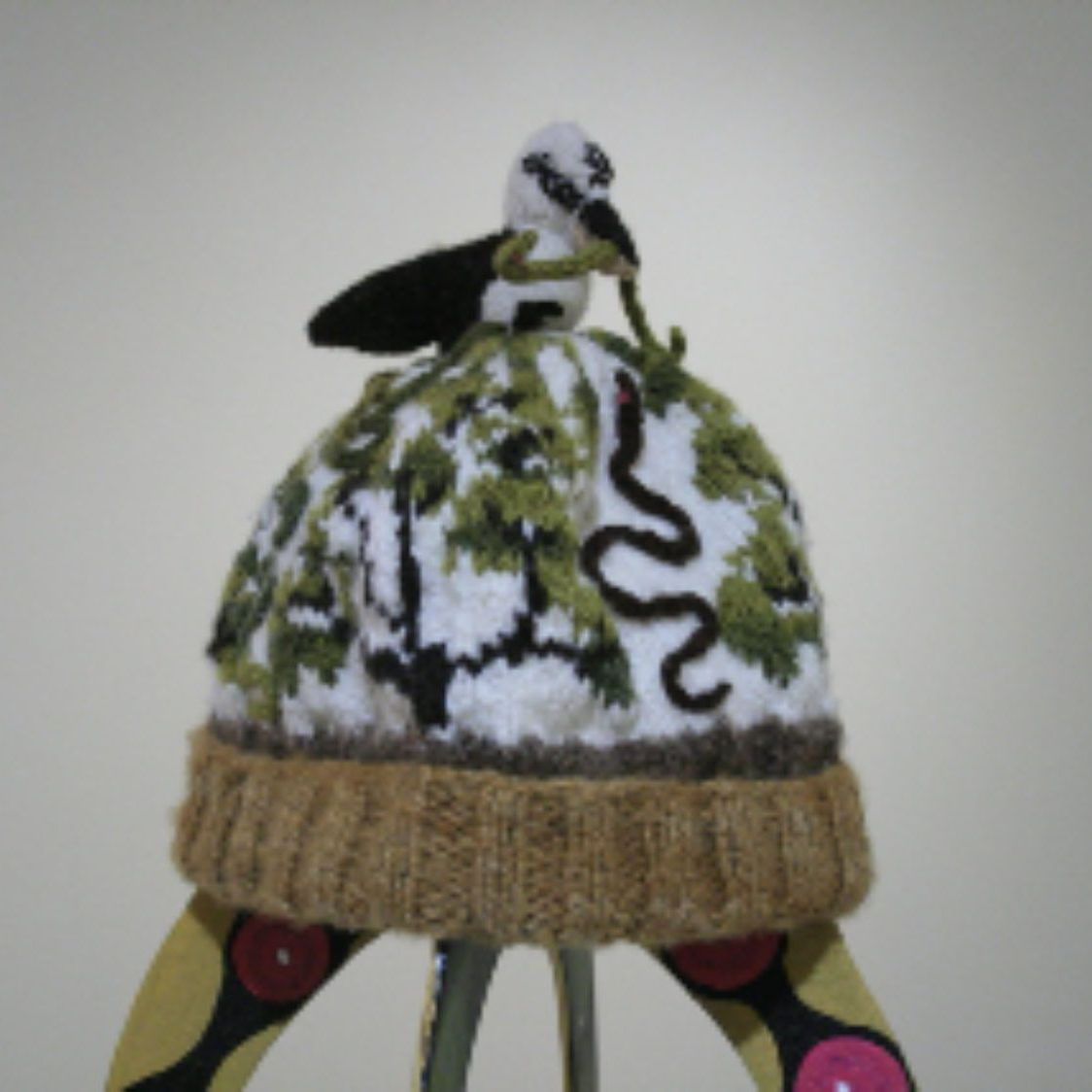 A hat with a bird and snake on it