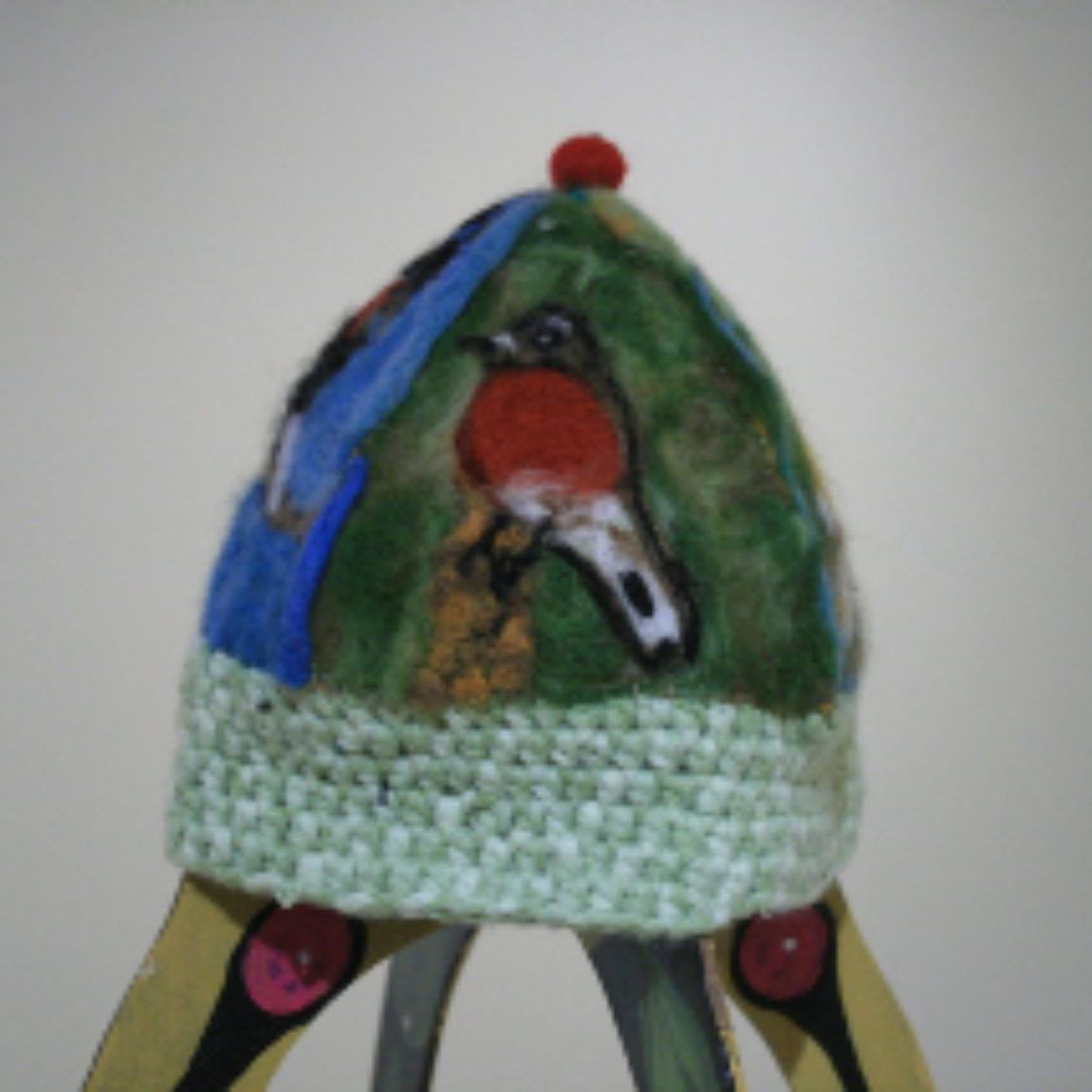 A hat with a bird on it is on a tripod