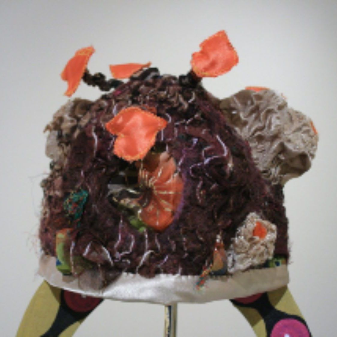 A hat with flowers on it is sitting on a stand