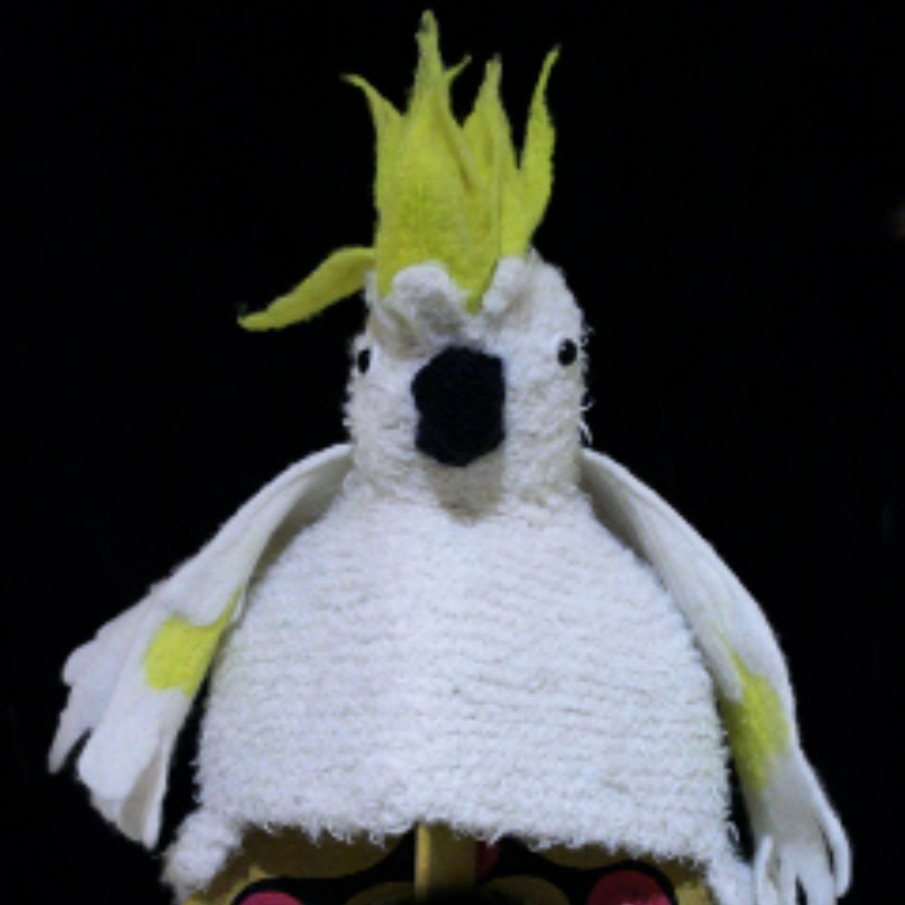 A stuffed white bird with a yellow crest on its head