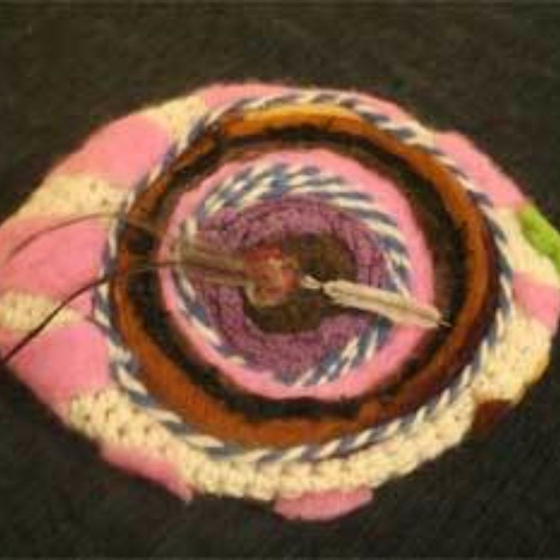 A close up of a knitted object that looks like an eye