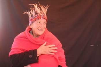 A woman wearing a crown and a red scarf is smiling