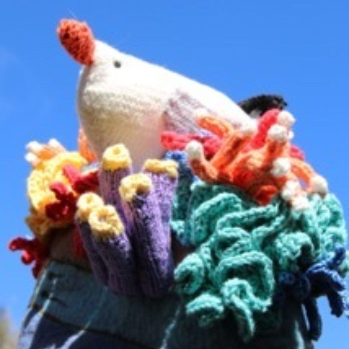 A stuffed animal is surrounded by crocheted corals
