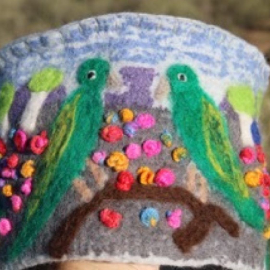 A person wearing a hat with birds and flowers on it