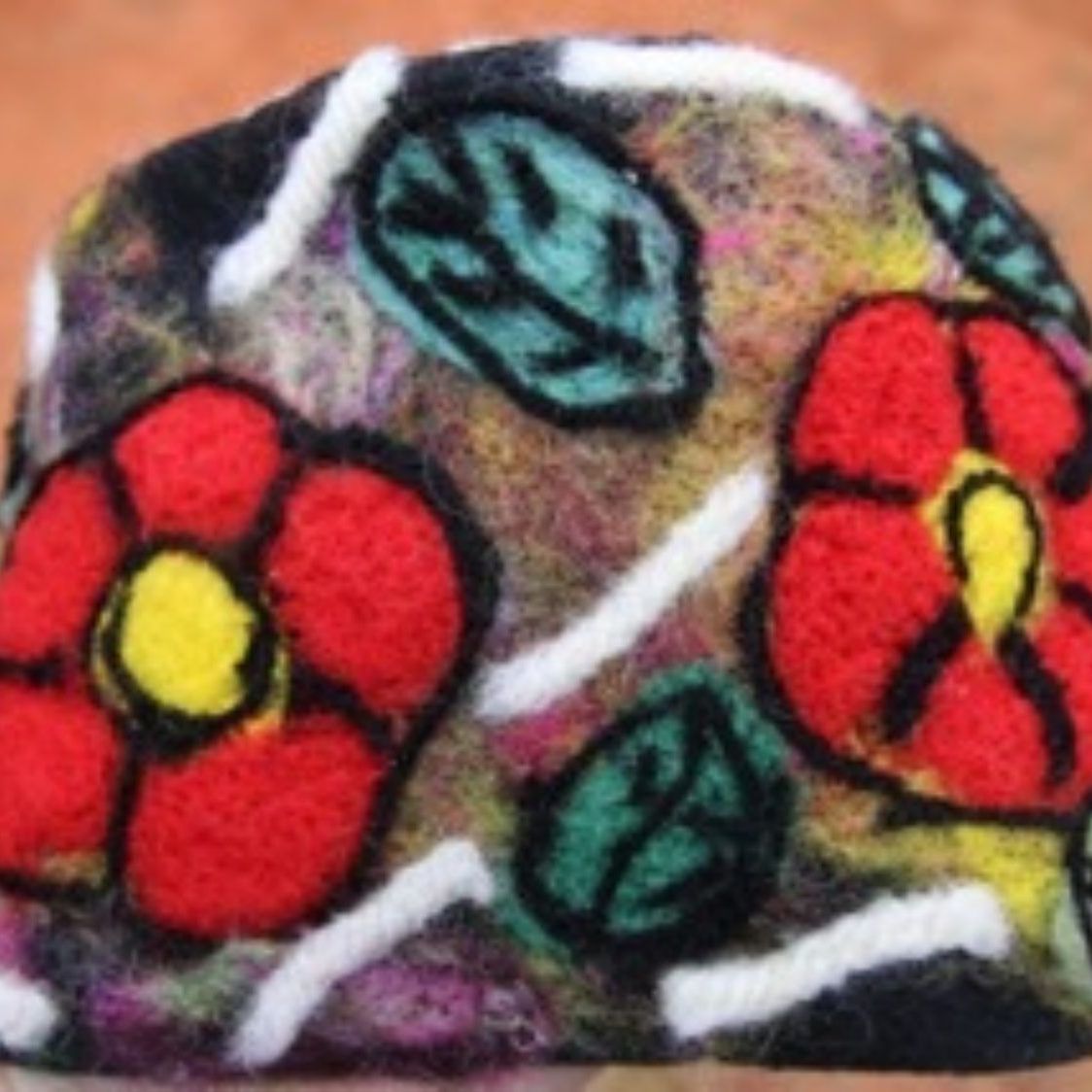 A colorful hat with flowers and leaves on it