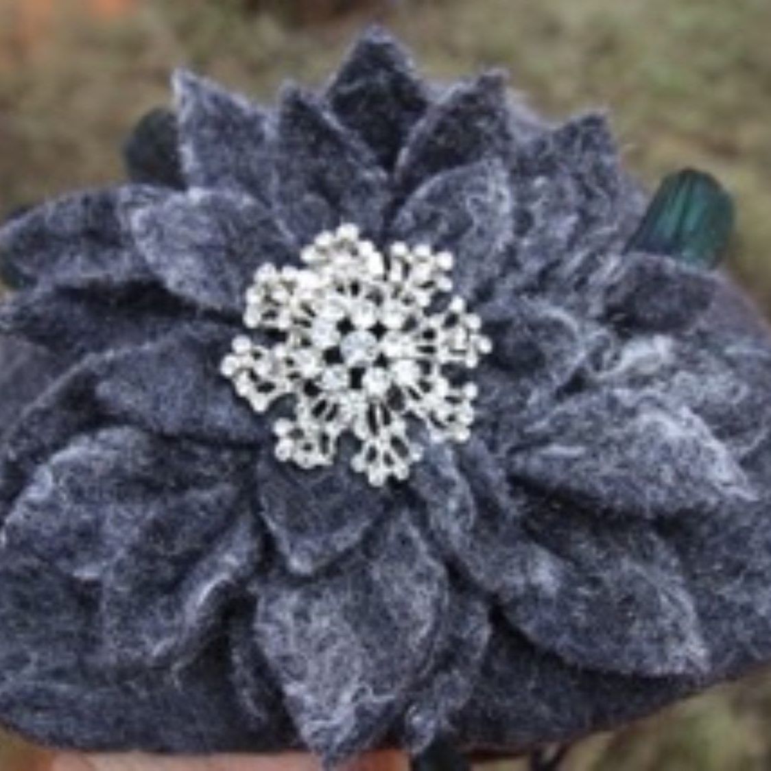 A person is holding a headband with a flower on it