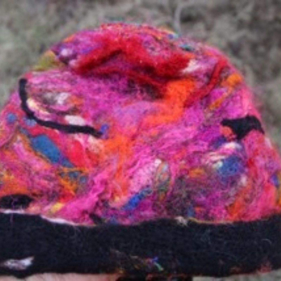 A person is holding a colorful hat in their hand