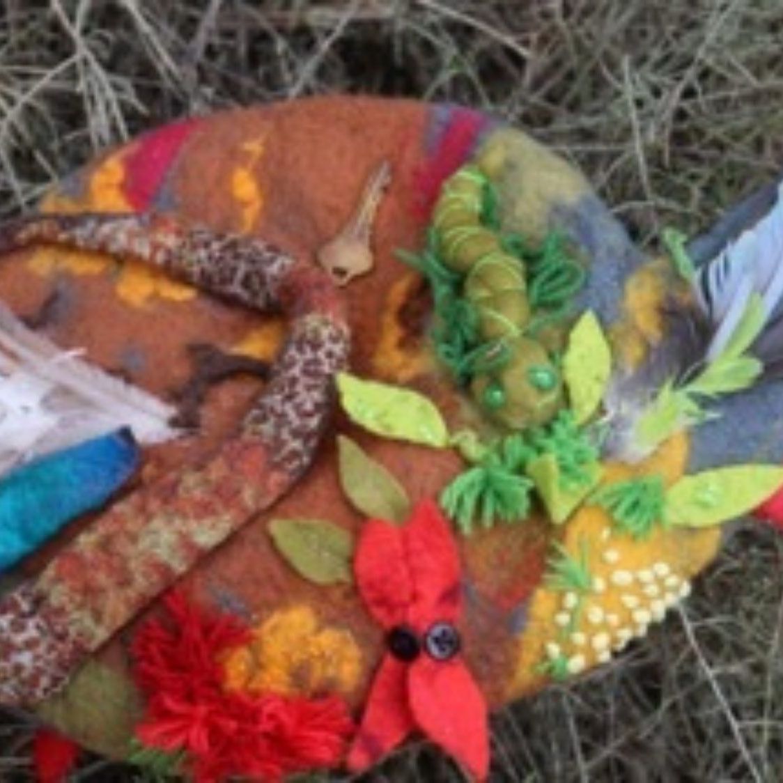 A stuffed animal with feathers and flowers on it