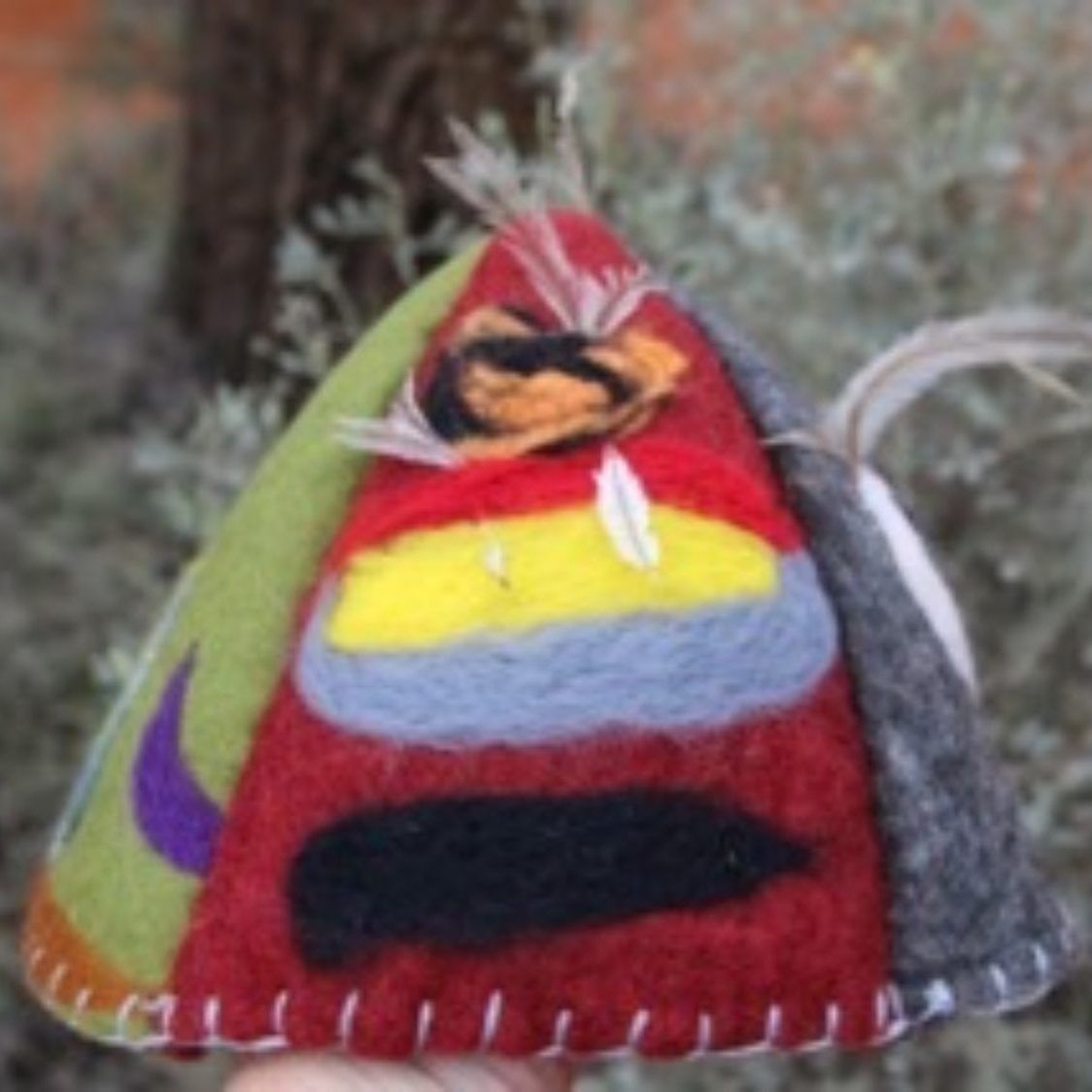 A person is holding a colorful hat in their hand