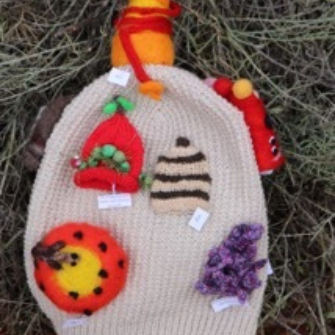 A knitted hat with stuffed animals on it