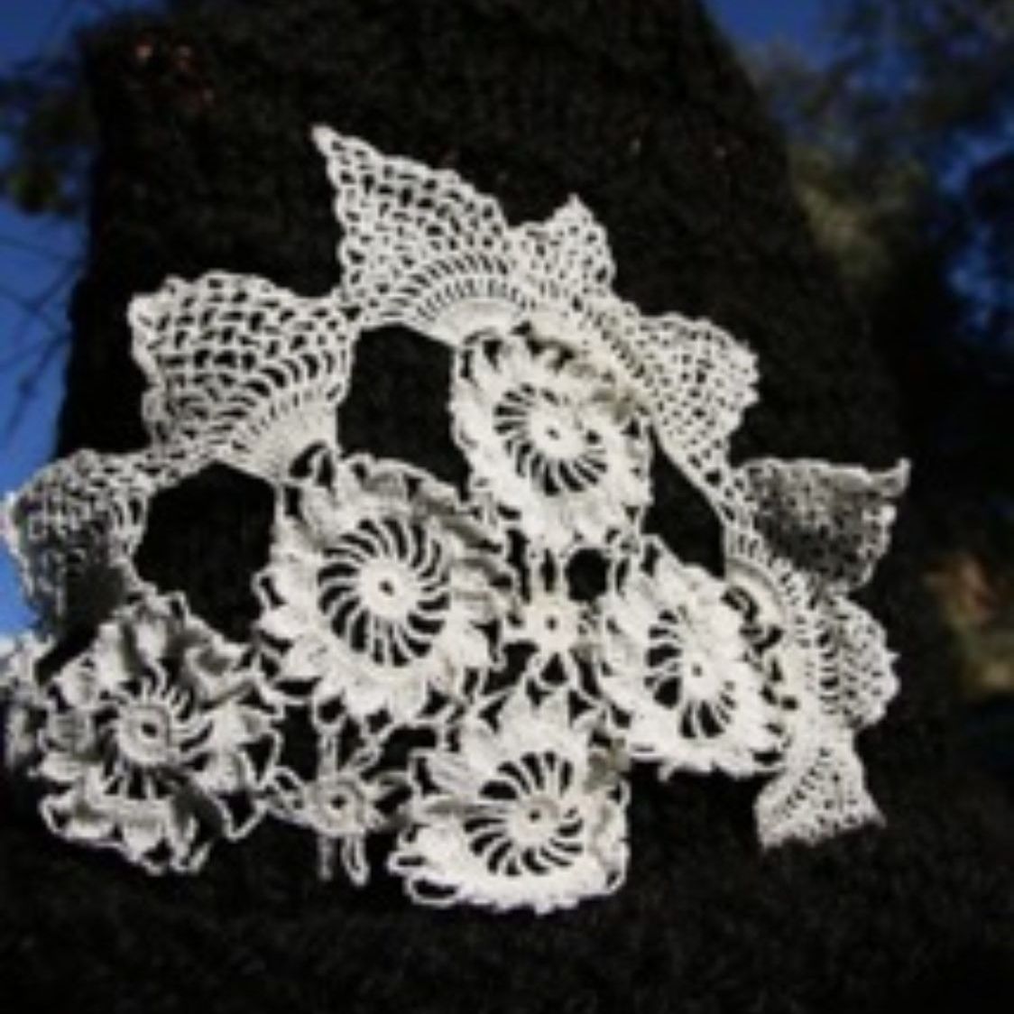 A piece of white lace is sitting on a black surface