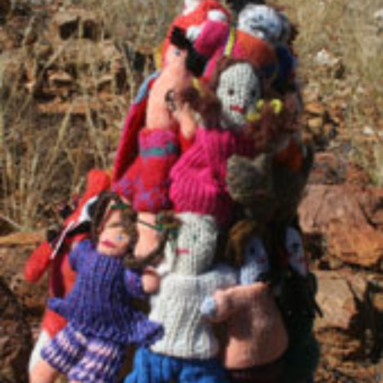 A person is carrying a pile of stuffed animals on their back.
