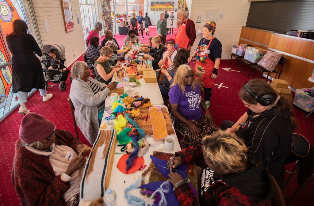 A group of people are sitting around a table making crafts.