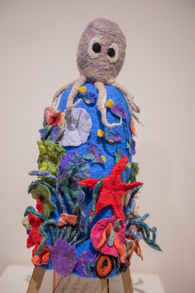 A sculpture of an octopus surrounded by sea creatures on a table.