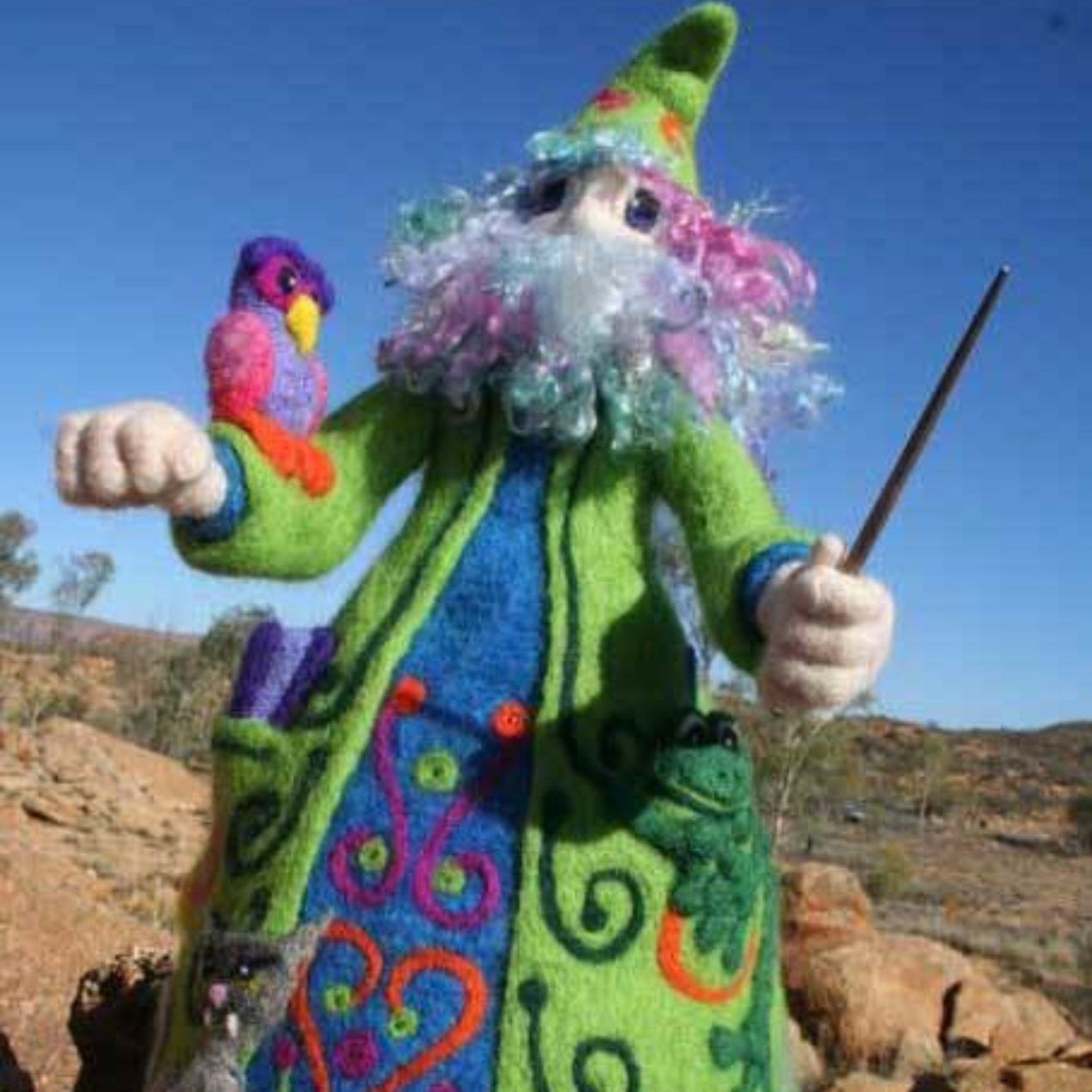 A stuffed wizard is holding a wand and a bird