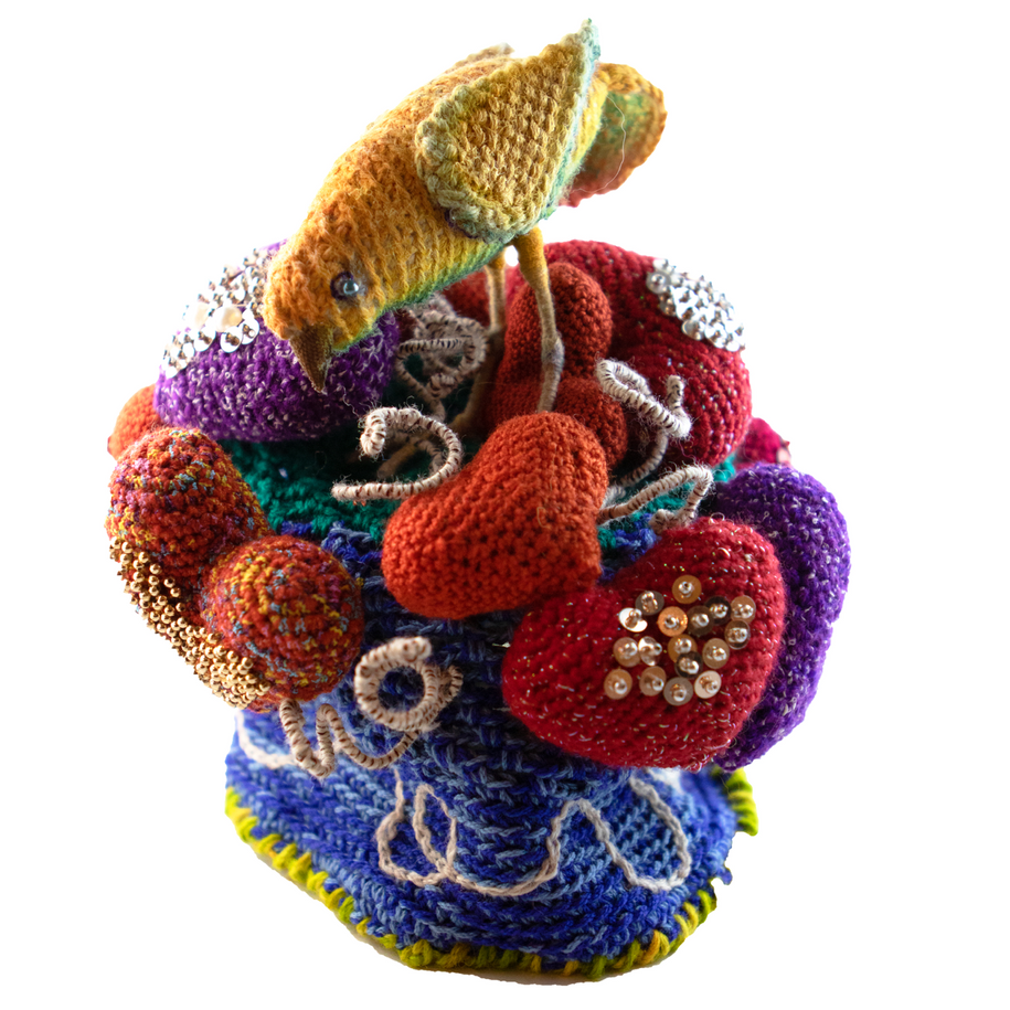A colorful knitted object with a fish on top of it